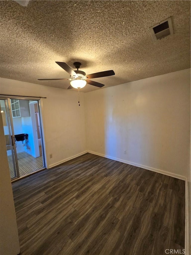 unfurnished room featuring baseboards, a textured ceiling, visible vents, and dark wood-style flooring