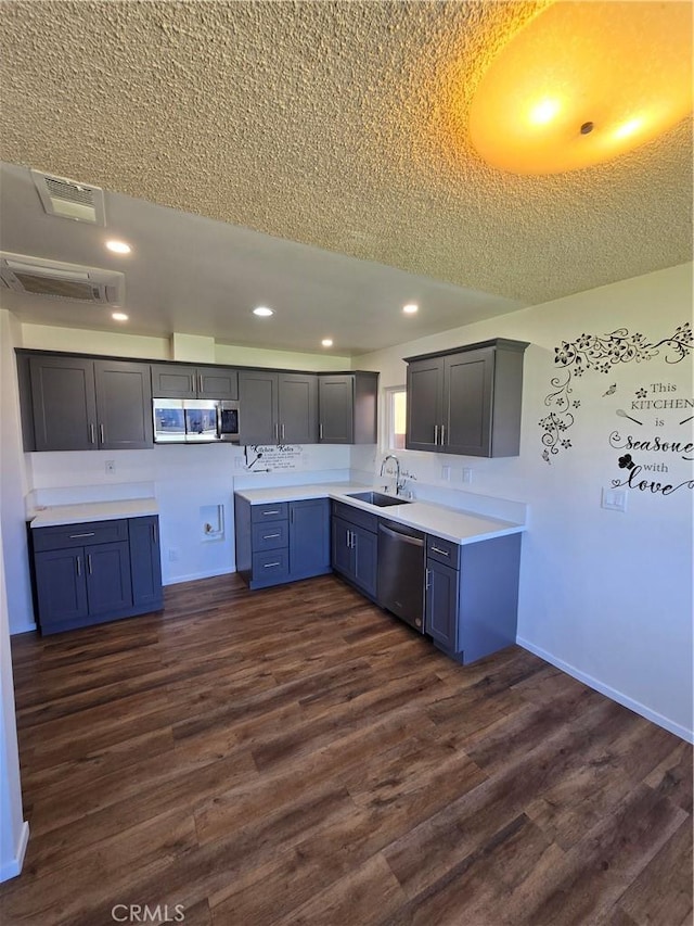 kitchen featuring visible vents, dark wood finished floors, stainless steel appliances, a sink, and recessed lighting