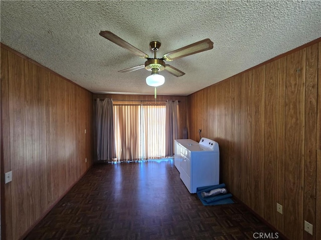 spare room with wood walls, washing machine and dryer, and a textured ceiling