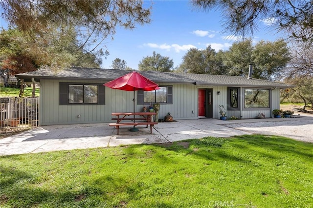 view of front of home featuring a front lawn, a patio area, and fence