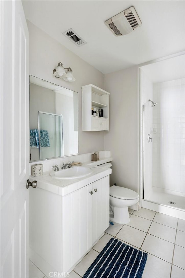 bathroom featuring toilet, a shower stall, and visible vents