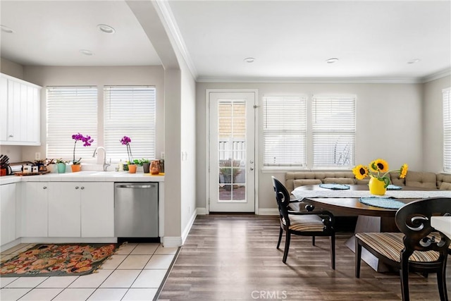 kitchen with tile counters, breakfast area, stainless steel dishwasher, and ornamental molding