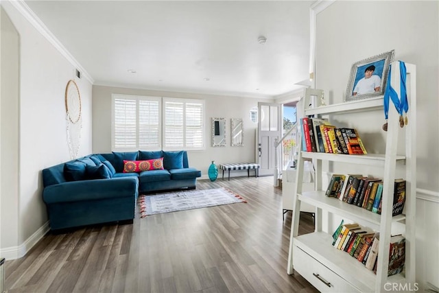 living area with ornamental molding, baseboards, and wood finished floors