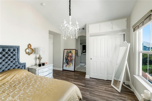 bedroom featuring lofted ceiling, visible vents, baseboards, dark wood finished floors, and an inviting chandelier