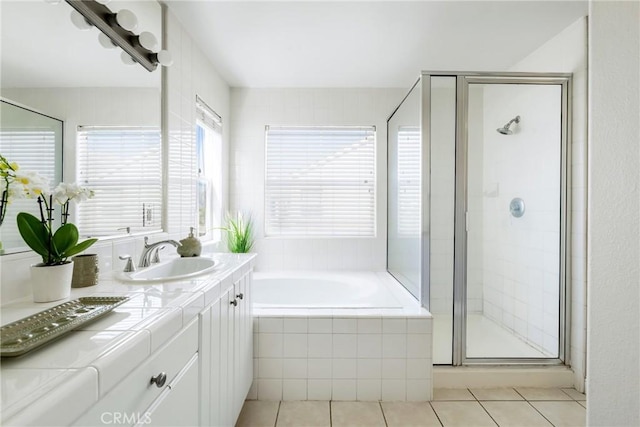 full bathroom featuring a stall shower, a garden tub, vanity, and tile patterned floors