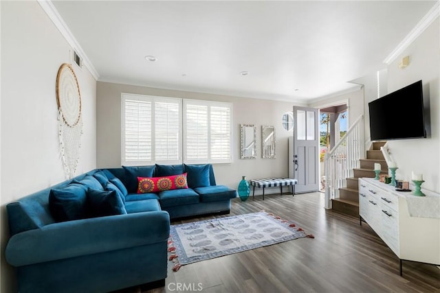 living room featuring wood finished floors, visible vents, crown molding, and stairs