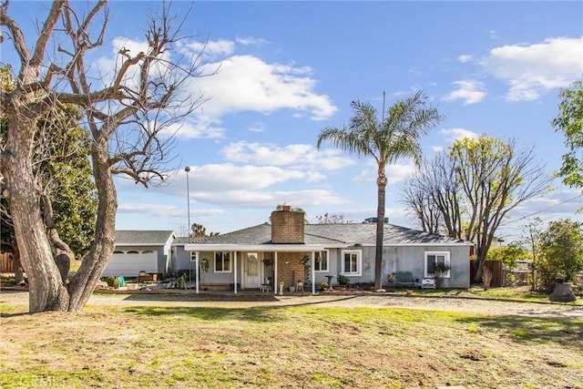 view of front of house featuring fence, a chimney, and a front lawn