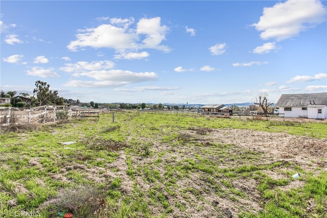 view of yard with a rural view and fence