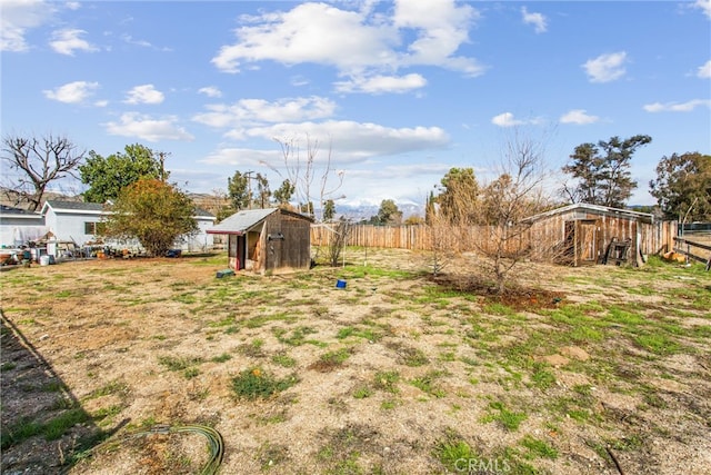 view of yard featuring an outdoor structure, fence, and a shed