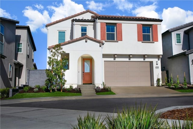 view of front of house with stucco siding, a tiled roof, concrete driveway, and an attached garage