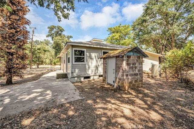 back of property featuring a shed, fence, and an outdoor structure