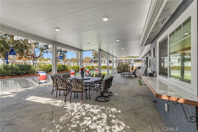 view of patio with outdoor dining area and fence