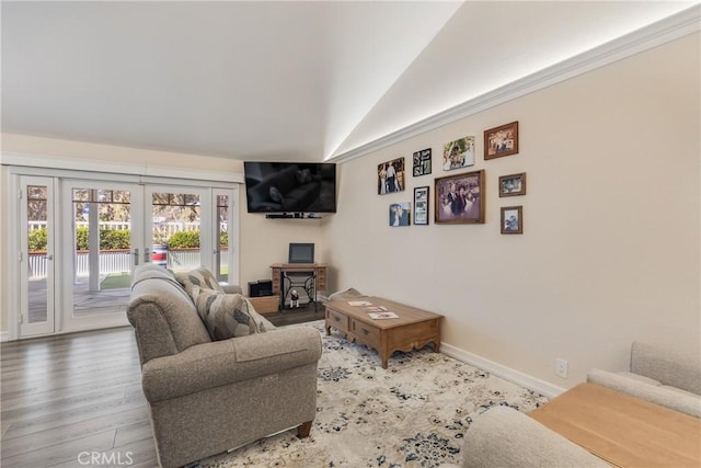 living area with vaulted ceiling, french doors, wood finished floors, and baseboards