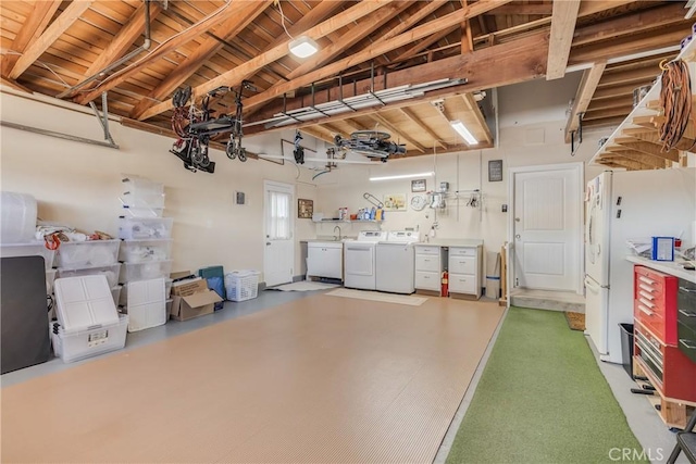 garage with wood ceiling, independent washer and dryer, and freestanding refrigerator