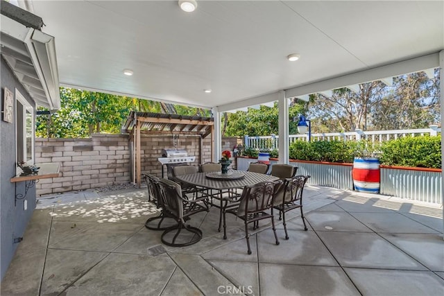 view of patio featuring outdoor dining area, fence, and area for grilling