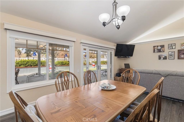 dining space featuring lofted ceiling, french doors, dark wood-type flooring, and a chandelier