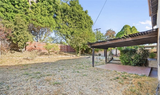 view of yard with fence, a pergola, and a patio