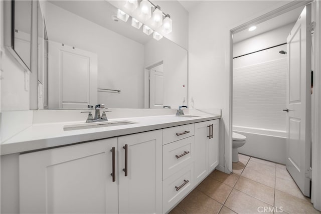 bathroom with tile patterned floors, a sink, toilet, and double vanity