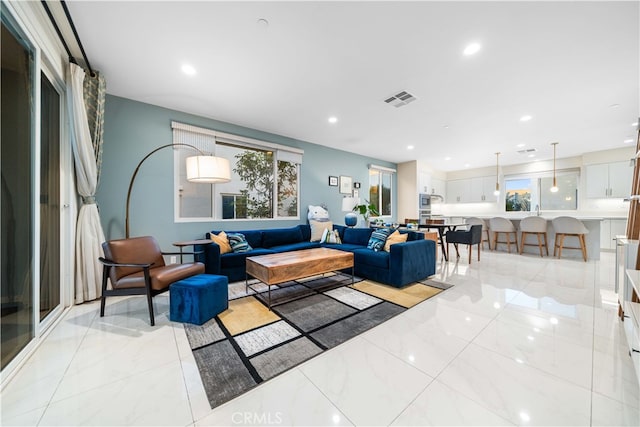 living room with recessed lighting, marble finish floor, and visible vents