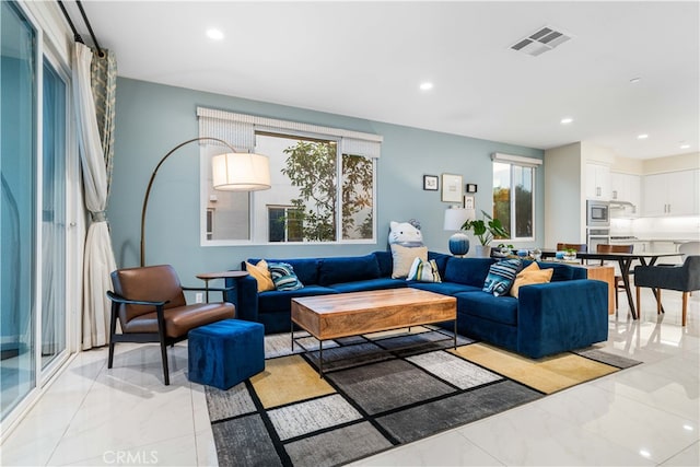 living room featuring marble finish floor, visible vents, and recessed lighting