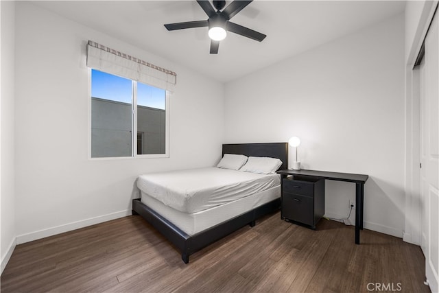 bedroom featuring a ceiling fan, baseboards, and dark wood-type flooring