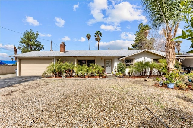 single story home featuring aphalt driveway, a chimney, a garage, and stucco siding