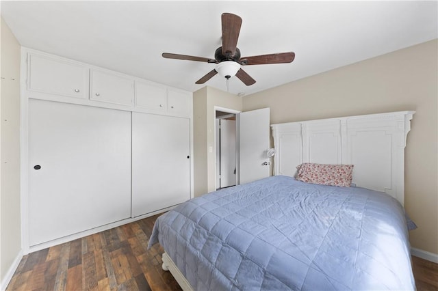 bedroom with ceiling fan, a closet, dark wood finished floors, and baseboards