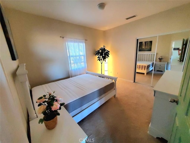 bedroom featuring visible vents and light carpet