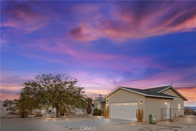 view of front of house featuring a garage, a shingled roof, fence, driveway, and stucco siding