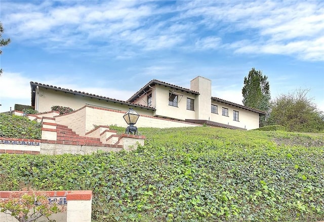 exterior space with a patio area, a tiled roof, and a yard