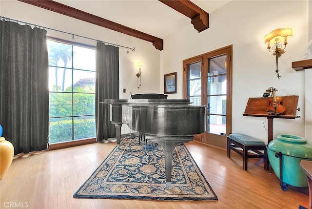 living area with beam ceiling, french doors, and wood finished floors