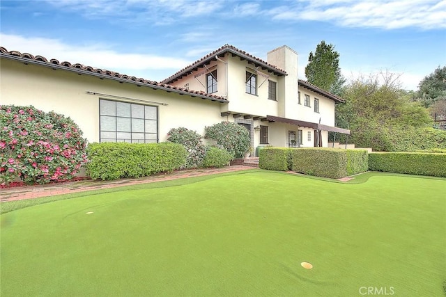 back of property featuring stucco siding and a tile roof