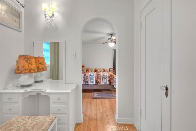 bedroom with light wood-style flooring and arched walkways