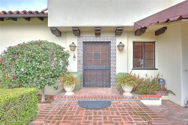 property entrance featuring stucco siding and a tile roof