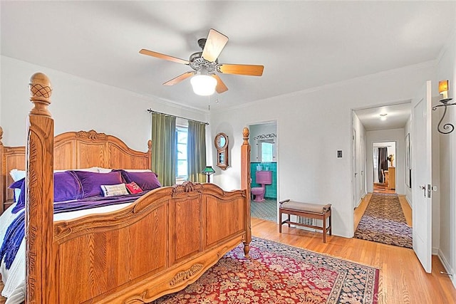 bedroom with ensuite bath, crown molding, light wood-style floors, and ceiling fan