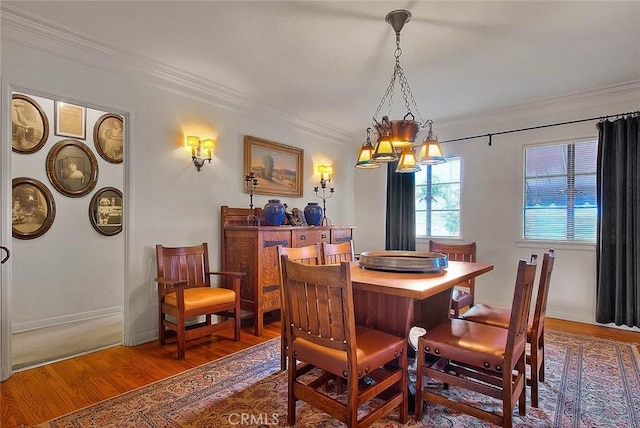 dining room featuring crown molding, baseboards, and wood finished floors