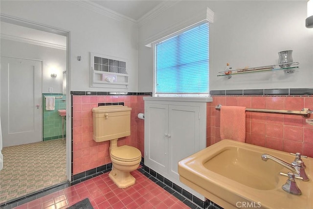 full bath with a wainscoted wall, toilet, a garden tub, ornamental molding, and tile patterned floors