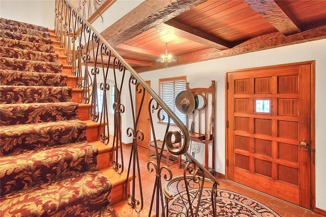 foyer entrance featuring beamed ceiling, wood ceiling, and stairs