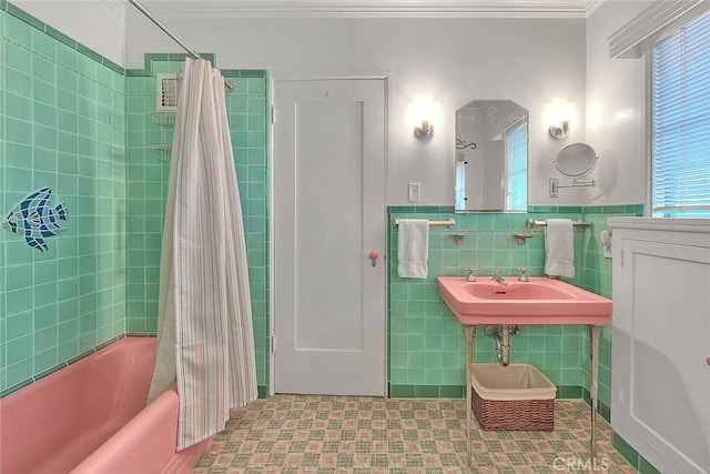 bathroom featuring a wainscoted wall, tile walls, shower / bath combo, and ornamental molding