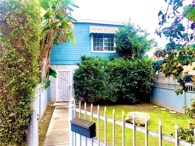 view of front facade featuring a front yard and fence