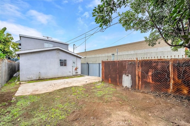 exterior space featuring a patio area, a detached garage, and fence