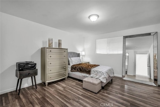 bedroom with baseboards and dark wood-style flooring