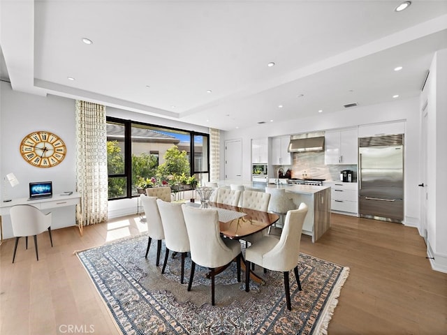 dining space with light wood-style flooring, visible vents, and recessed lighting