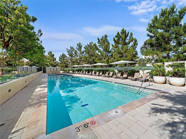 pool with a patio and fence
