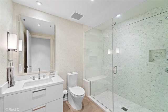 bathroom with toilet, a stall shower, vanity, and visible vents