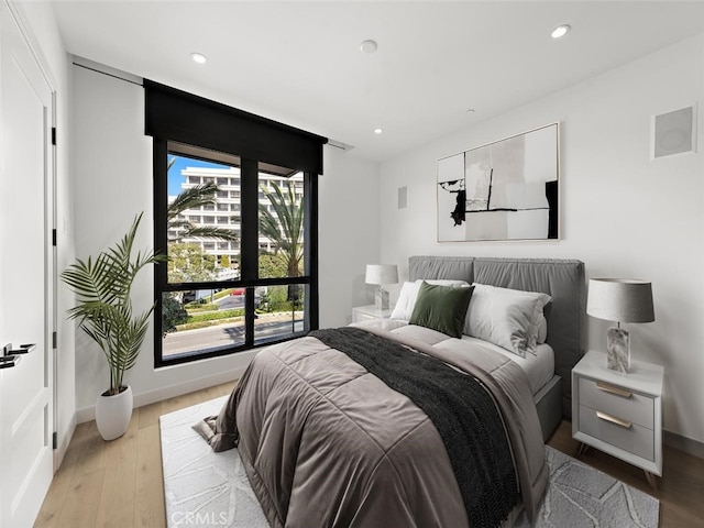 bedroom featuring baseboards, light wood finished floors, and recessed lighting
