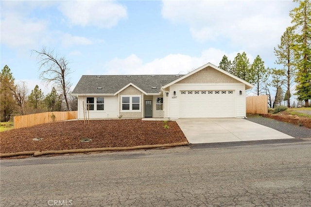 ranch-style home featuring an attached garage, fence, concrete driveway, and roof with shingles