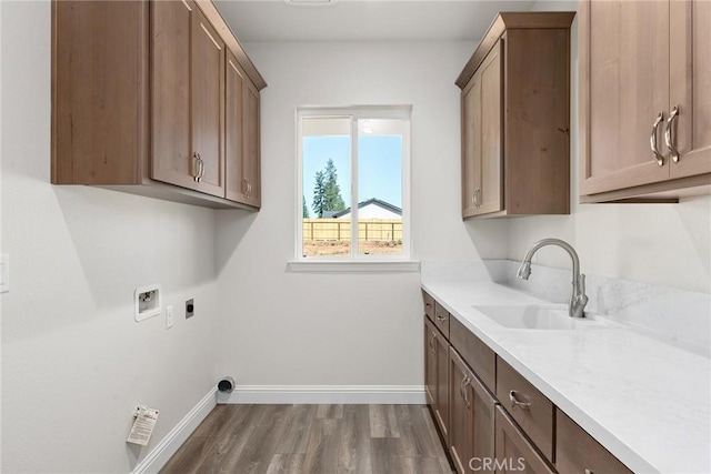 laundry area with cabinet space, baseboards, hookup for a washing machine, hookup for an electric dryer, and a sink