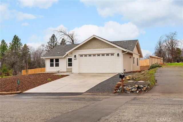 single story home with concrete driveway, an attached garage, and fence