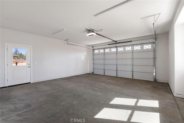 garage featuring a garage door opener and baseboards